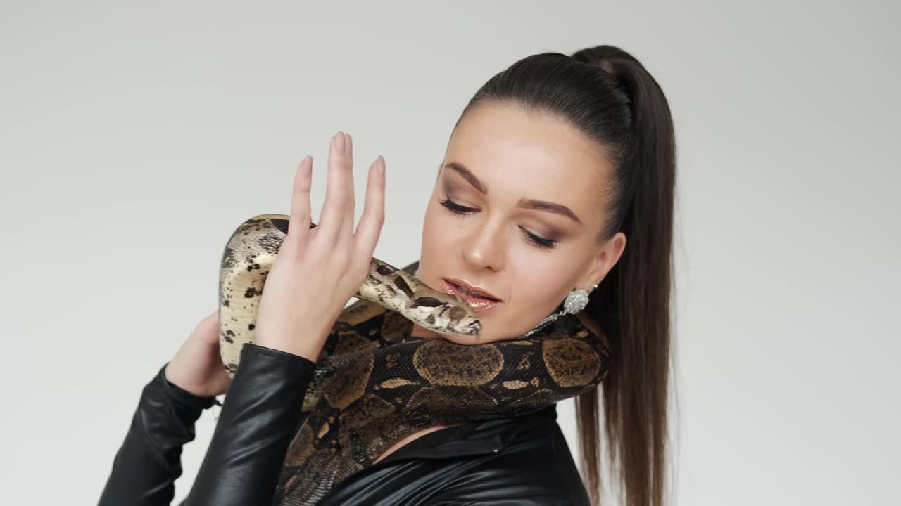 蛇头放在女人的手上。慢动作视频下载