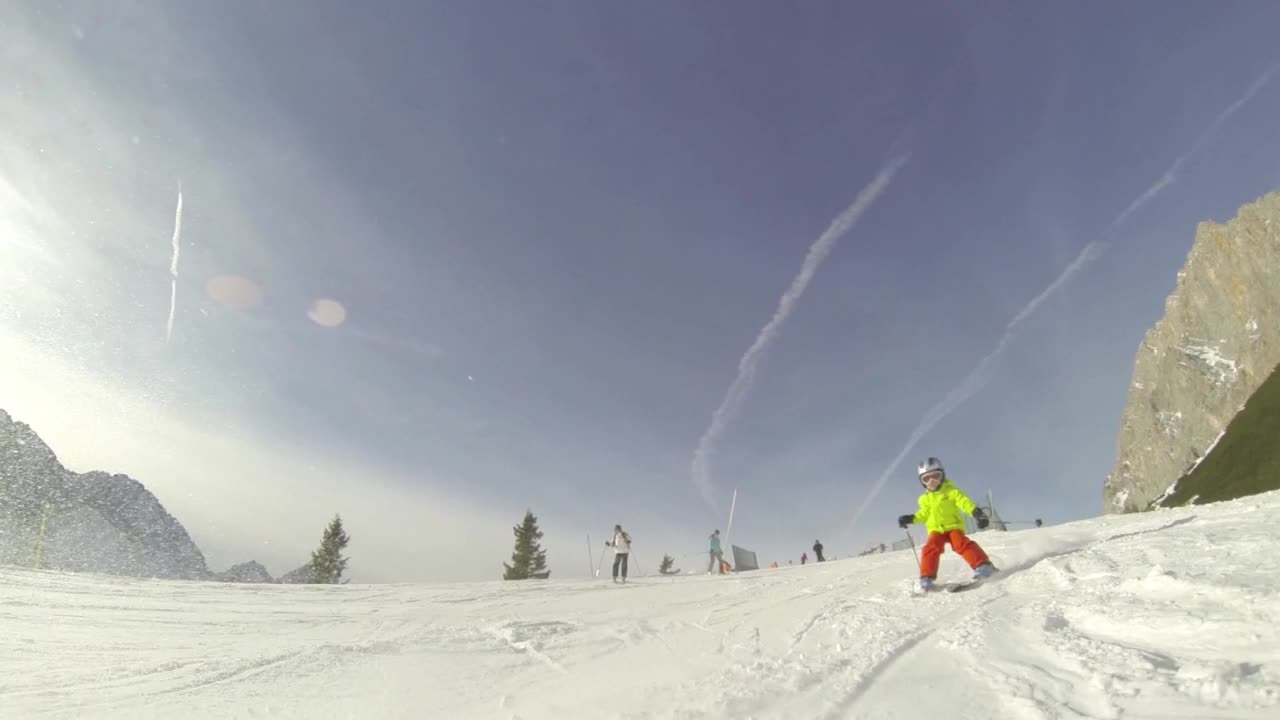 一个小男孩滑下坡滑雪的动作镜头视频下载