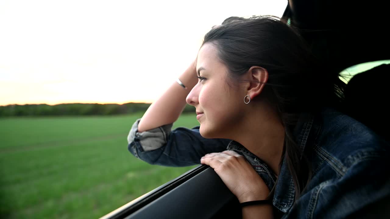 侧面的年轻女子探出车窗视频下载
