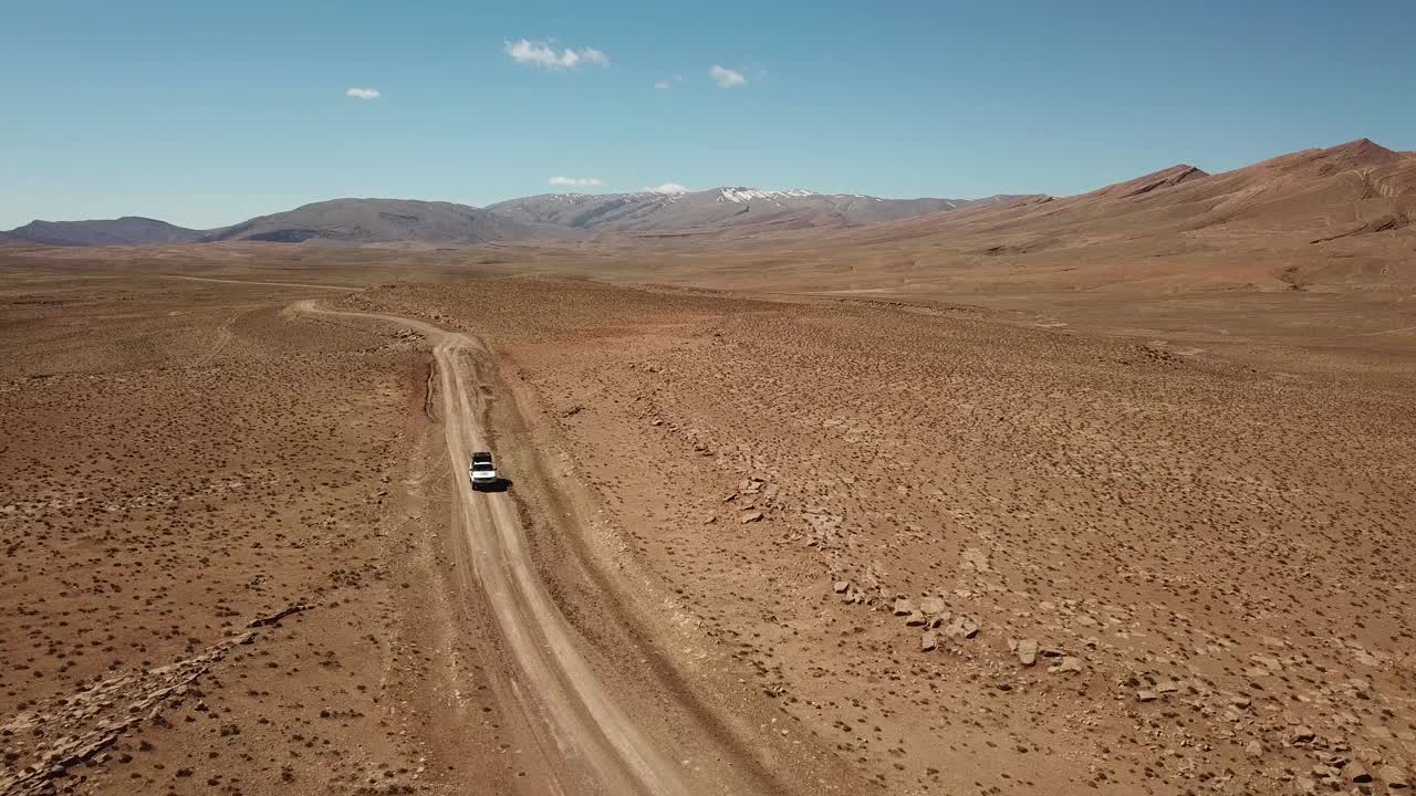 无人机拍摄的一辆越野车在摩洛哥沙漠行驶视频素材