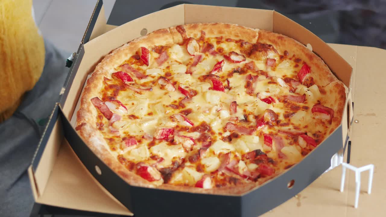 俯视图手拿披萨片从纸板盒。视频下载
