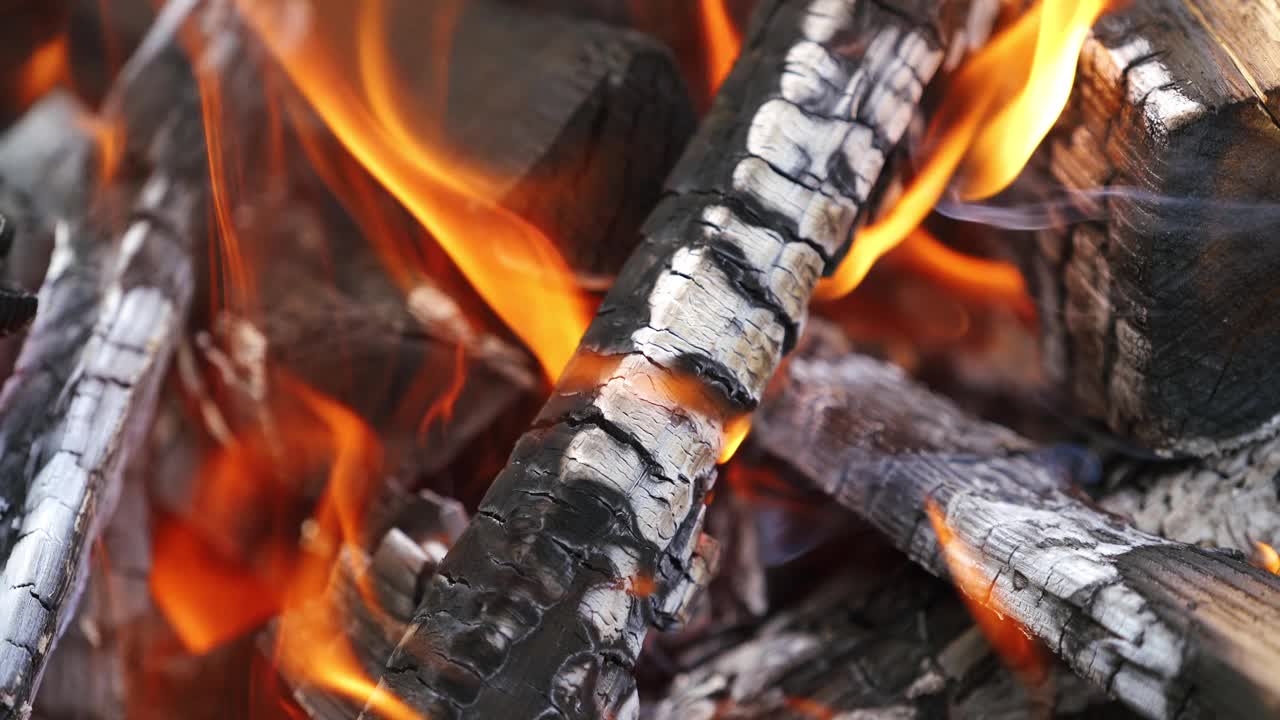 闷烧的木头在火中燃烧。燃烧原木作为抽象背景。火中燃烧的木头的热余烬。特写镜头。视频素材