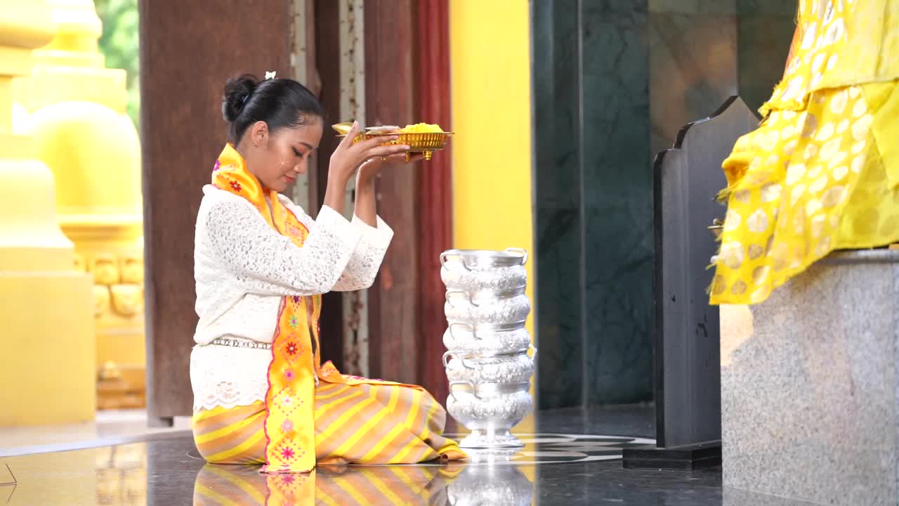缅甸妇女在一座寺庙里表达她们的敬意。穿着缅甸传统服装的东南亚年轻女孩参观佛教寺庙。视频下载