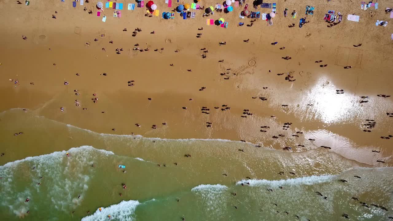 航拍的海岸，沙丘，海滩盖尔在葡萄牙。游客们在海里游泳，在雨伞下放松。视频素材