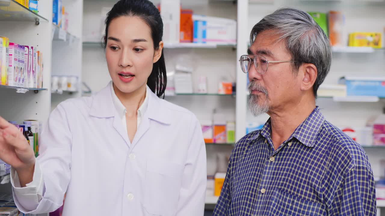 一位高级男子在药店和女药剂师交谈。女药师在药房协助向老年病人客户讲解药物。视频素材