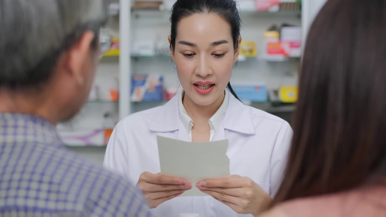 自信的亚洲药剂师在药店室内对客户谈论药物。视频素材