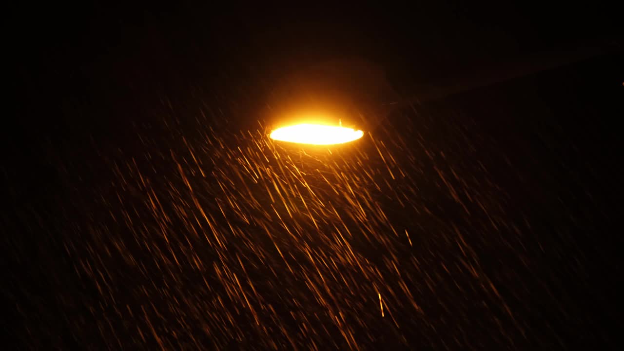 在街道上明亮的灯柱上看到的暴雨倾盆而下。视频素材