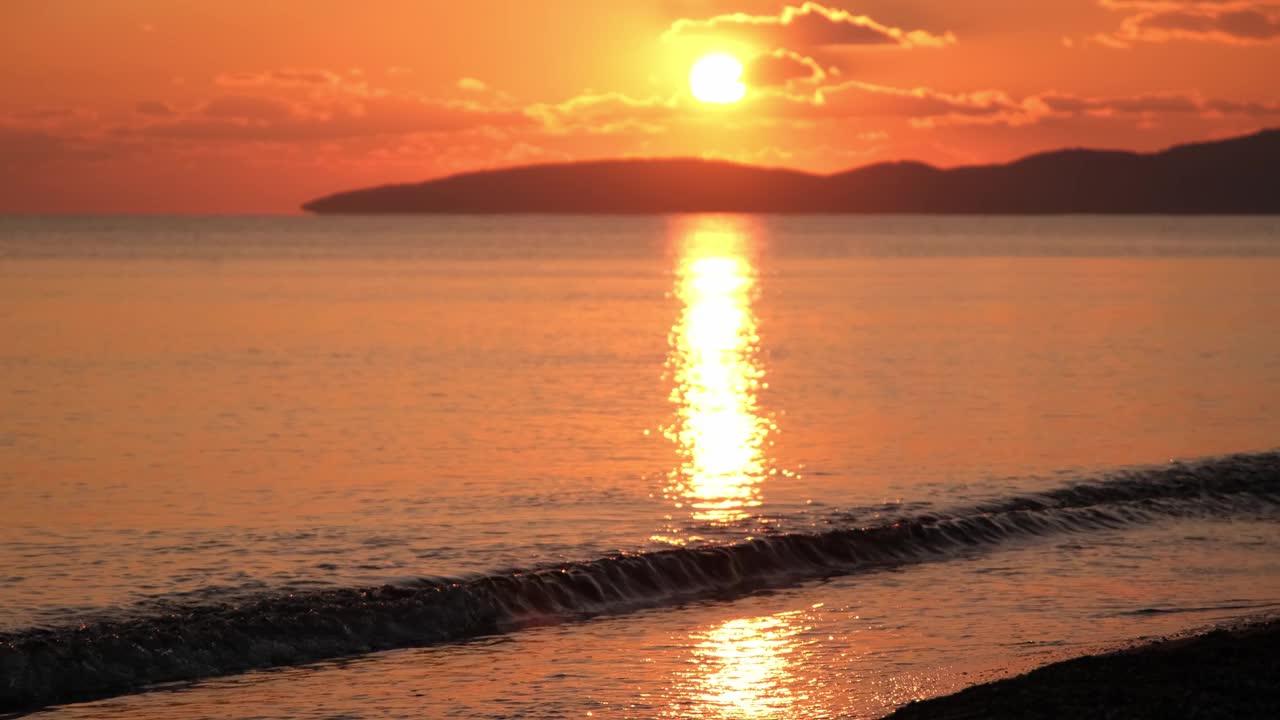 红色日落在海上视频4K。太阳落到地平线上。红色的天空，黄色的太阳和惊人的海洋。夏日夕阳海景。夏威夷海滩日落。太阳在旋转的云奇妙的自然日落视频素材