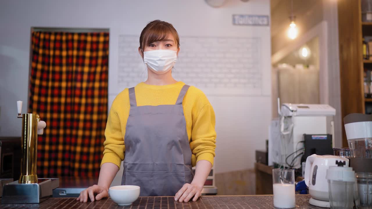 在café上戴着防护面罩的快乐女服务员的画像视频素材