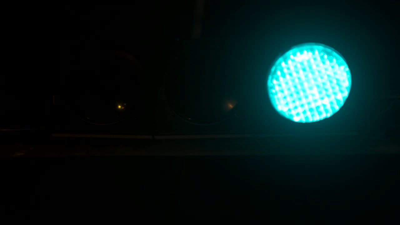 交通灯在晚上由绿转红。垂直悬挂交通灯视频下载