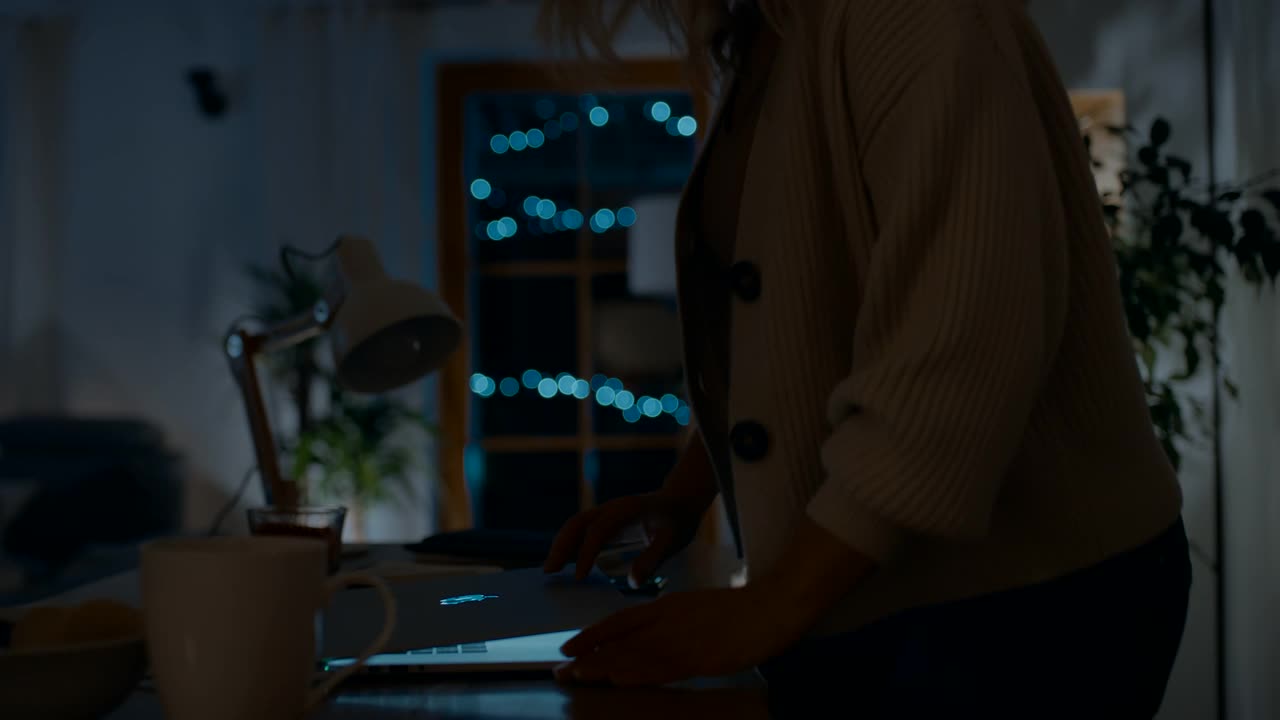 一个女人晚上开始在笔记本电脑上写东西视频素材