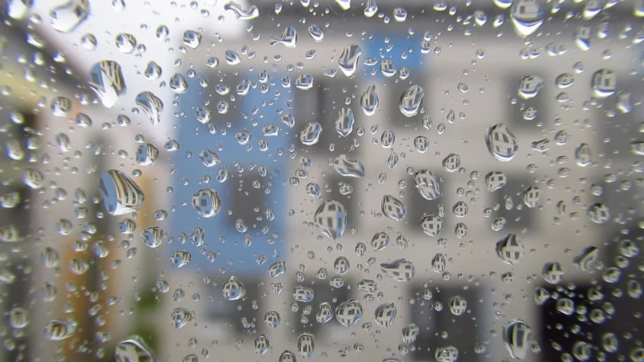 雨天窗户视图与近距离的雨滴和窗户反射在他们视频素材