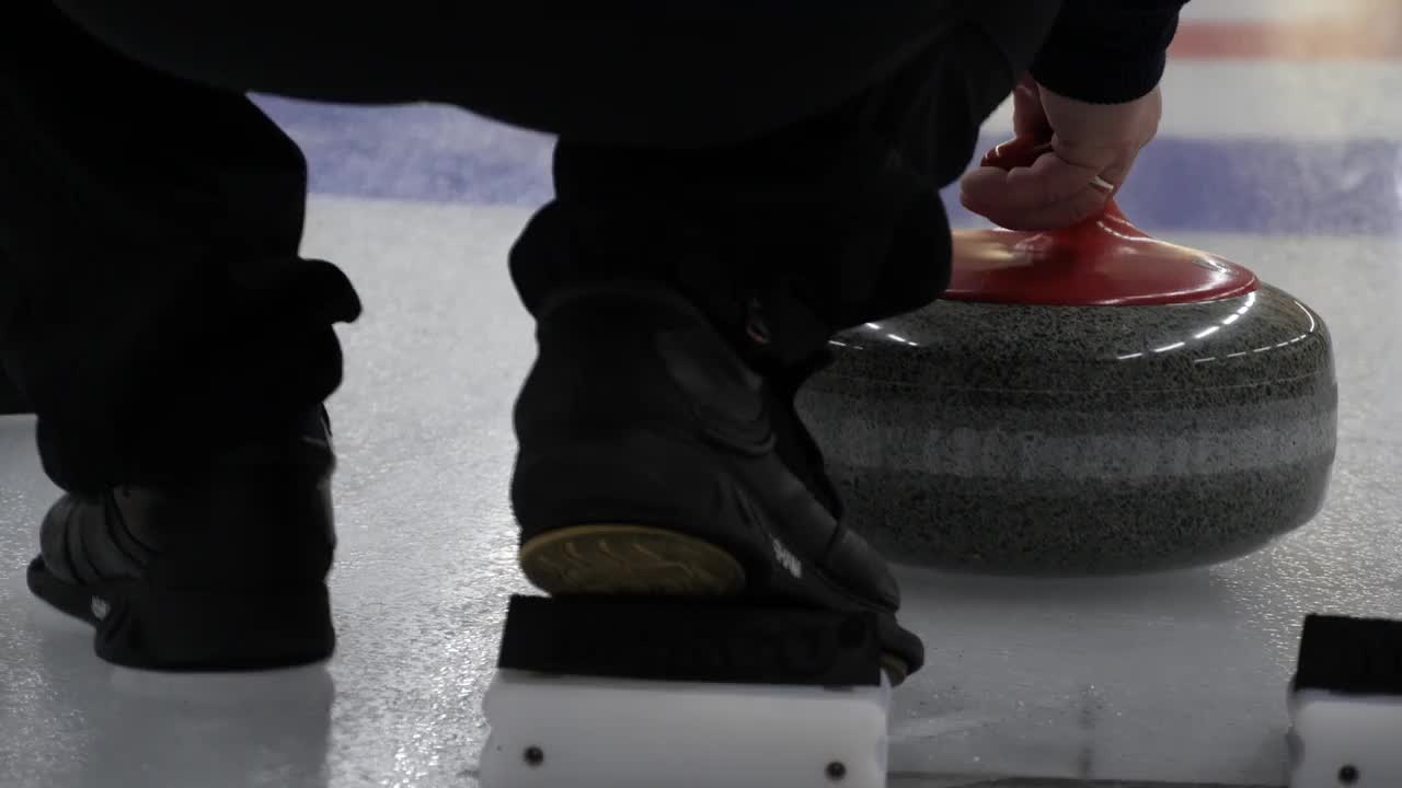 冰壶比赛。冰壶运动员正在溜冰场上玩冰壶游戏。花岗岩在冰原上滑动。视频素材