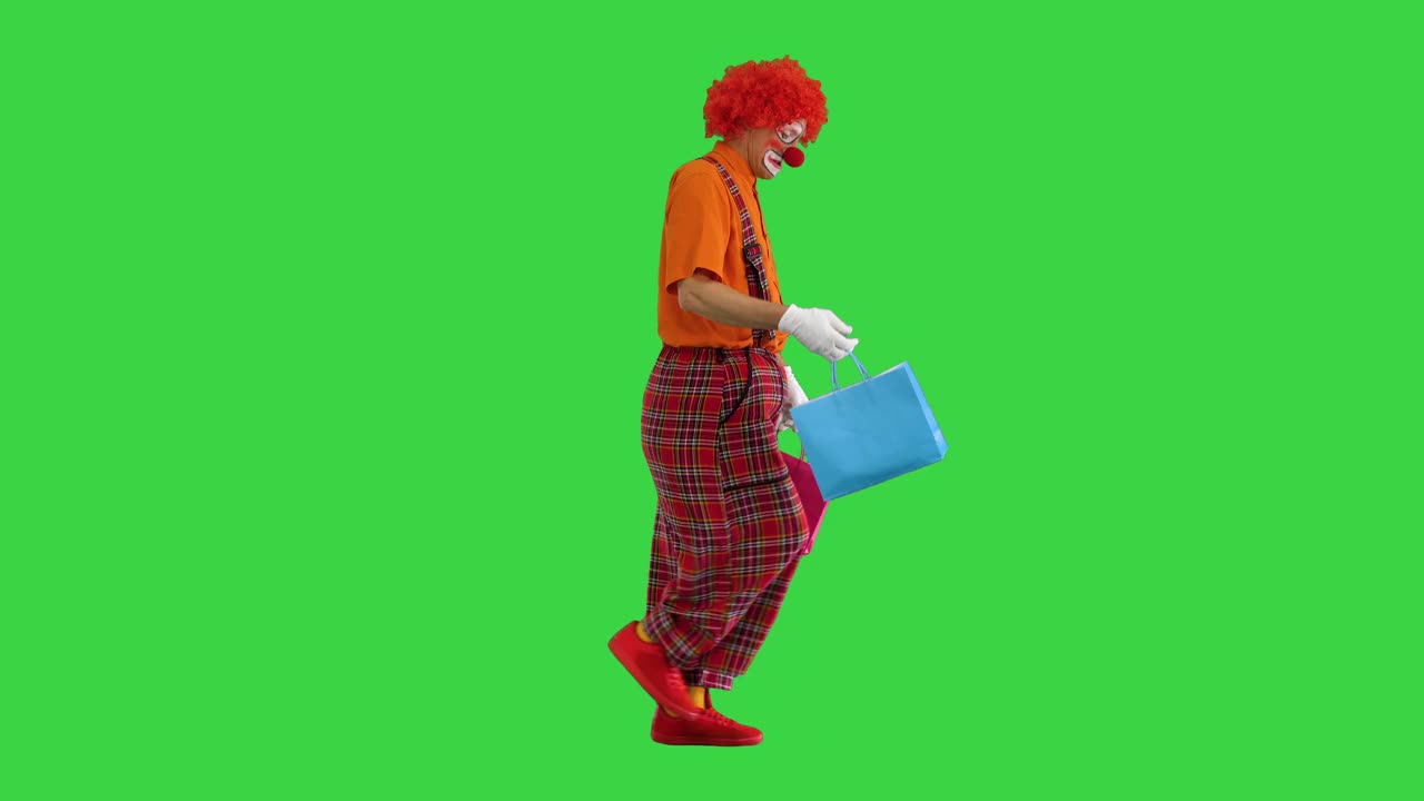 有趣的小丑在一个绿色屏幕购物袋，色度键视频素材