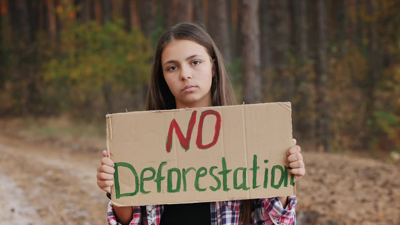 少女海报上写着“禁止砍伐森林”视频下载