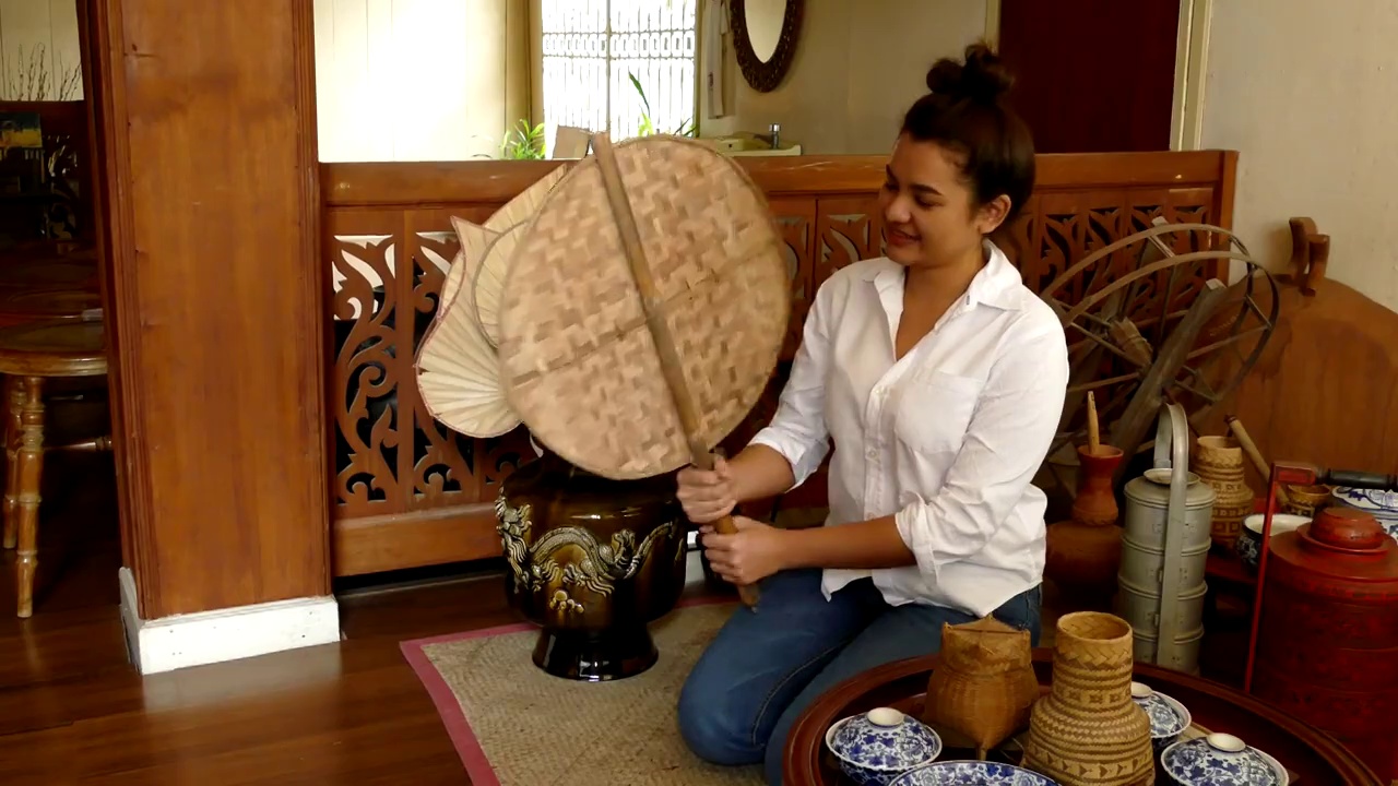 亚洲妇女用泰国传统的竹制硬扇住在古老的木屋里视频下载