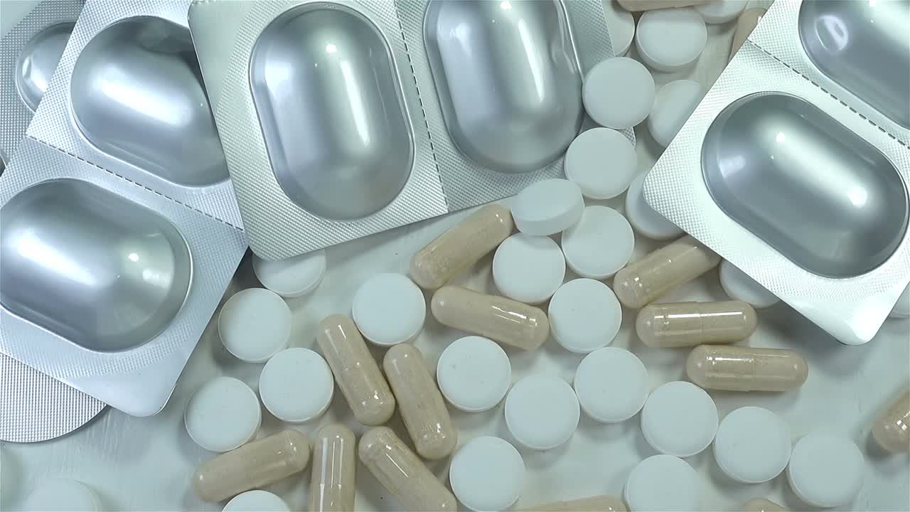 在一堆药丸上的银泡里装着医用胶囊视频素材