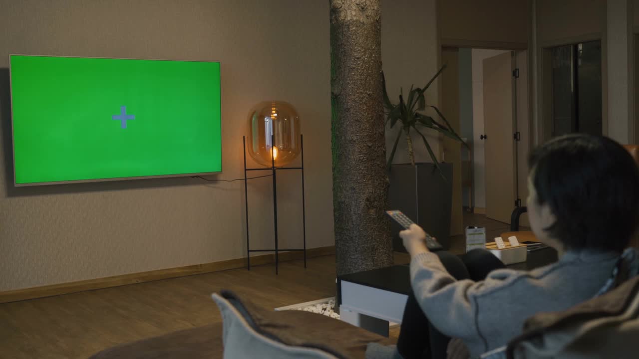 亚洲妇女看绿色色度键屏幕在家里视频素材