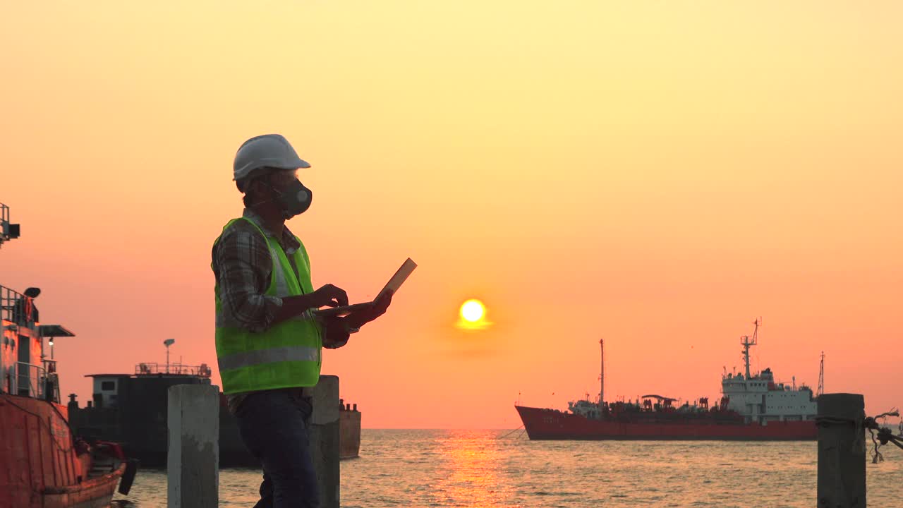 工程师在夕阳背景下的建筑工地为建筑行业工作。视频素材