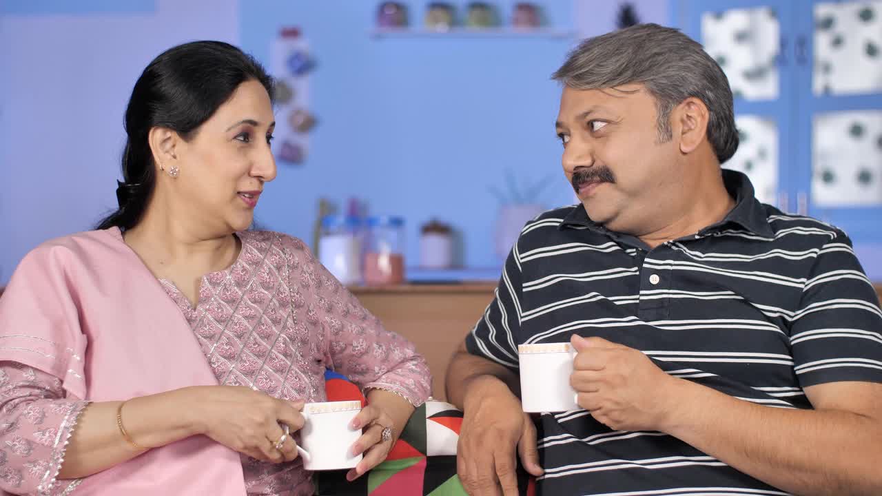 一对幸福的中年夫妇在家里聊天喝早茶视频素材