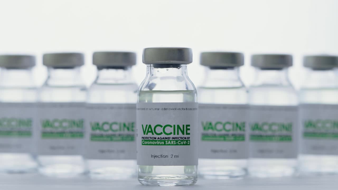 研究实验室，戴手套的医生拿着注射用疫苗。接种疫苗的概念,大流行。宏。瓶子、小瓶、水壶在白光背景上视频素材