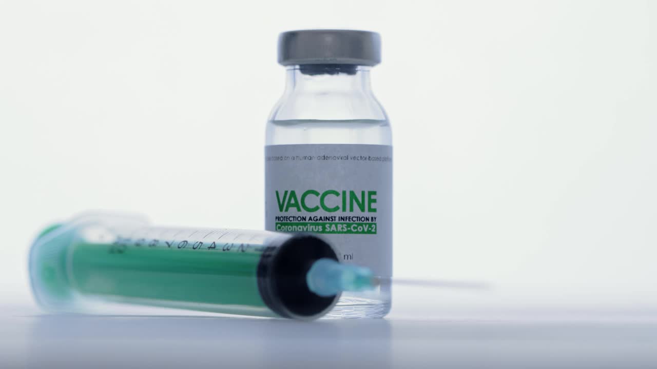 在科研实验室，手戴医用防护手套，从疫苗瓶中取出注射器进行注射。接种疫苗的概念,大流行。宏。小瓶在前景中视频素材