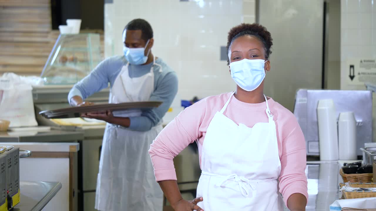 非裔美国人戴着面具在咖啡馆厨房工作视频下载