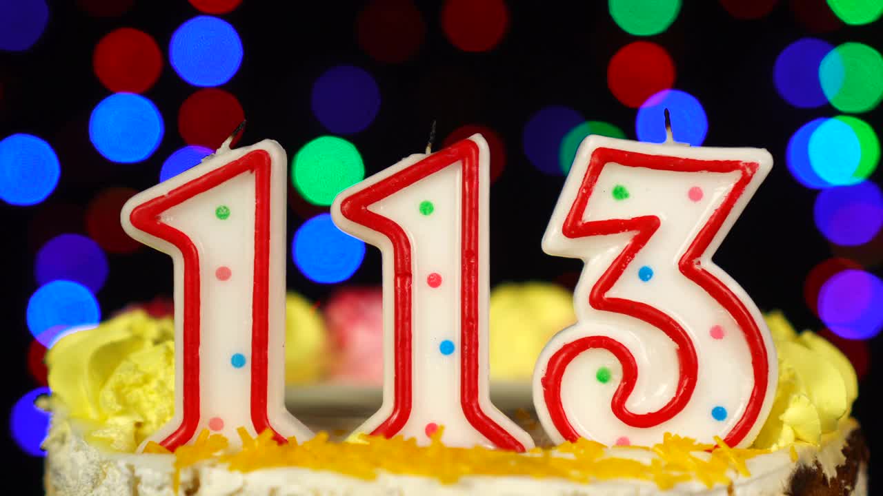 113号生日蛋糕上面有燃烧的蜡烛。视频素材