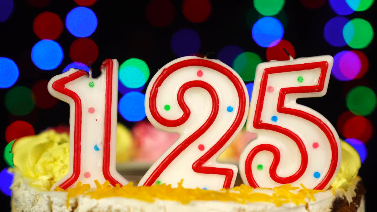 125号生日蛋糕上面有燃烧的蜡烛。视频素材