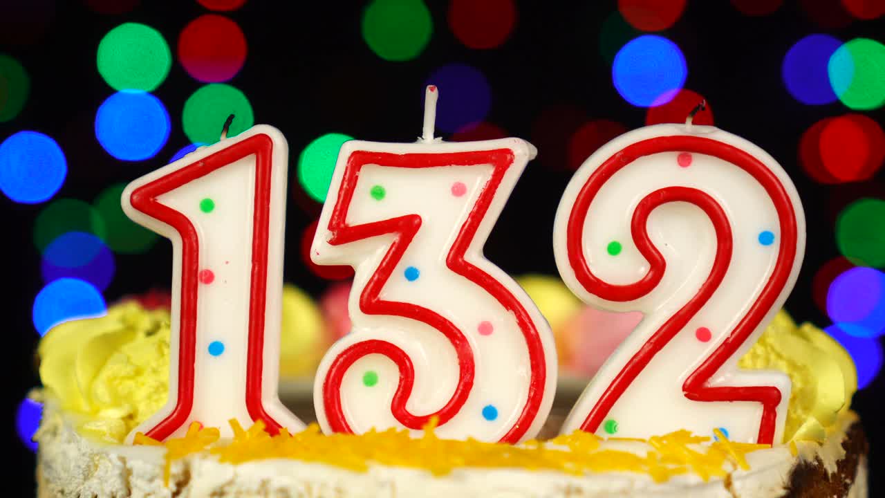 132号生日蛋糕上面有燃烧的蜡烛。视频素材