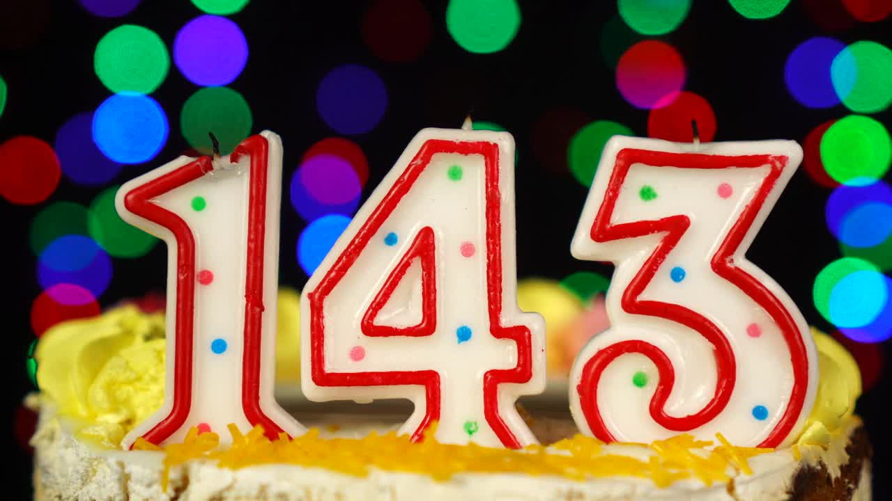 143号生日蛋糕上面有燃烧的蜡烛。视频素材