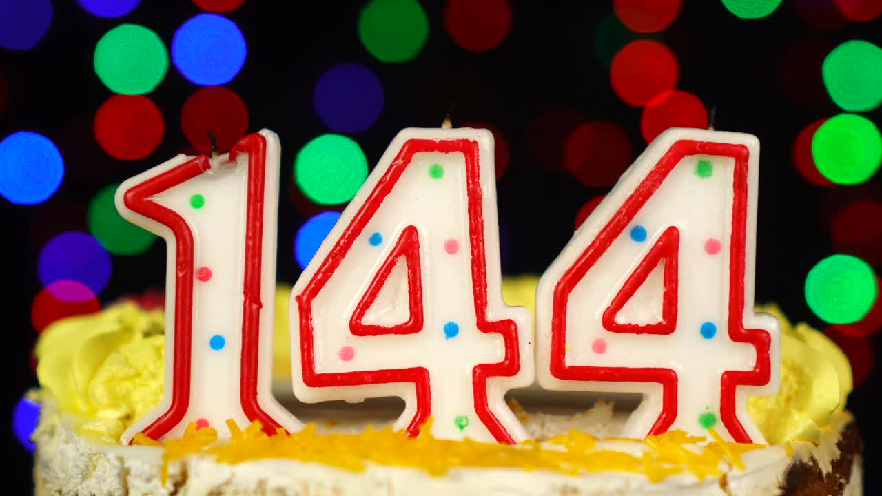 144号生日蛋糕上面有燃烧的蜡烛。视频素材