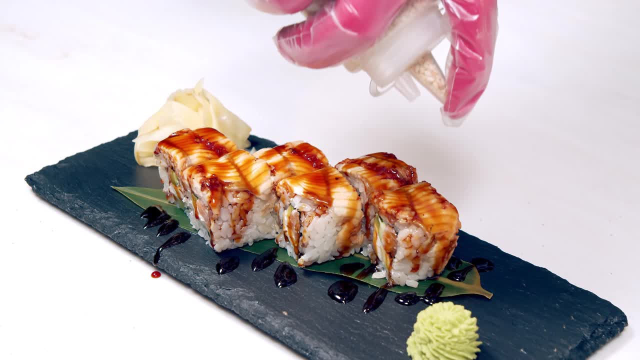 特写的美味寿司卷与烟熏鳗鱼在盘子上。在餐馆里做寿司卷。副本的空间。视频素材