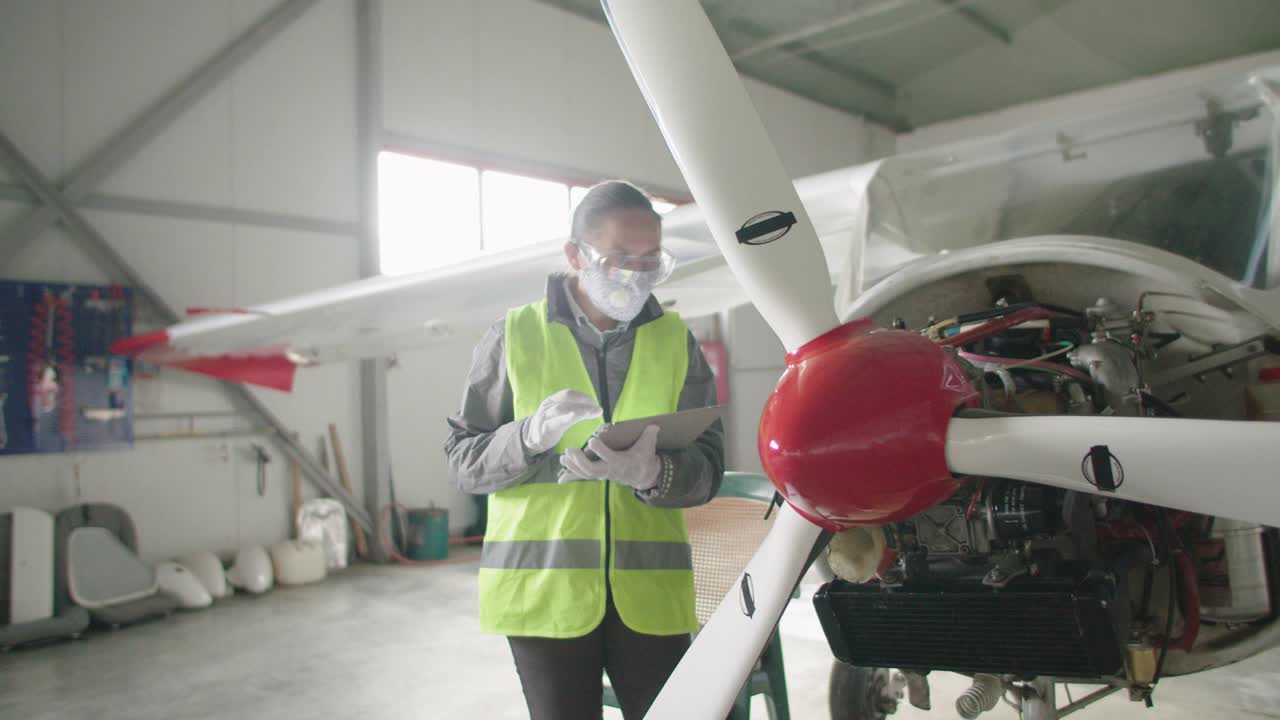 飞机工程师在飞机库里检查飞机引擎，然后把它放回飞行。视频素材