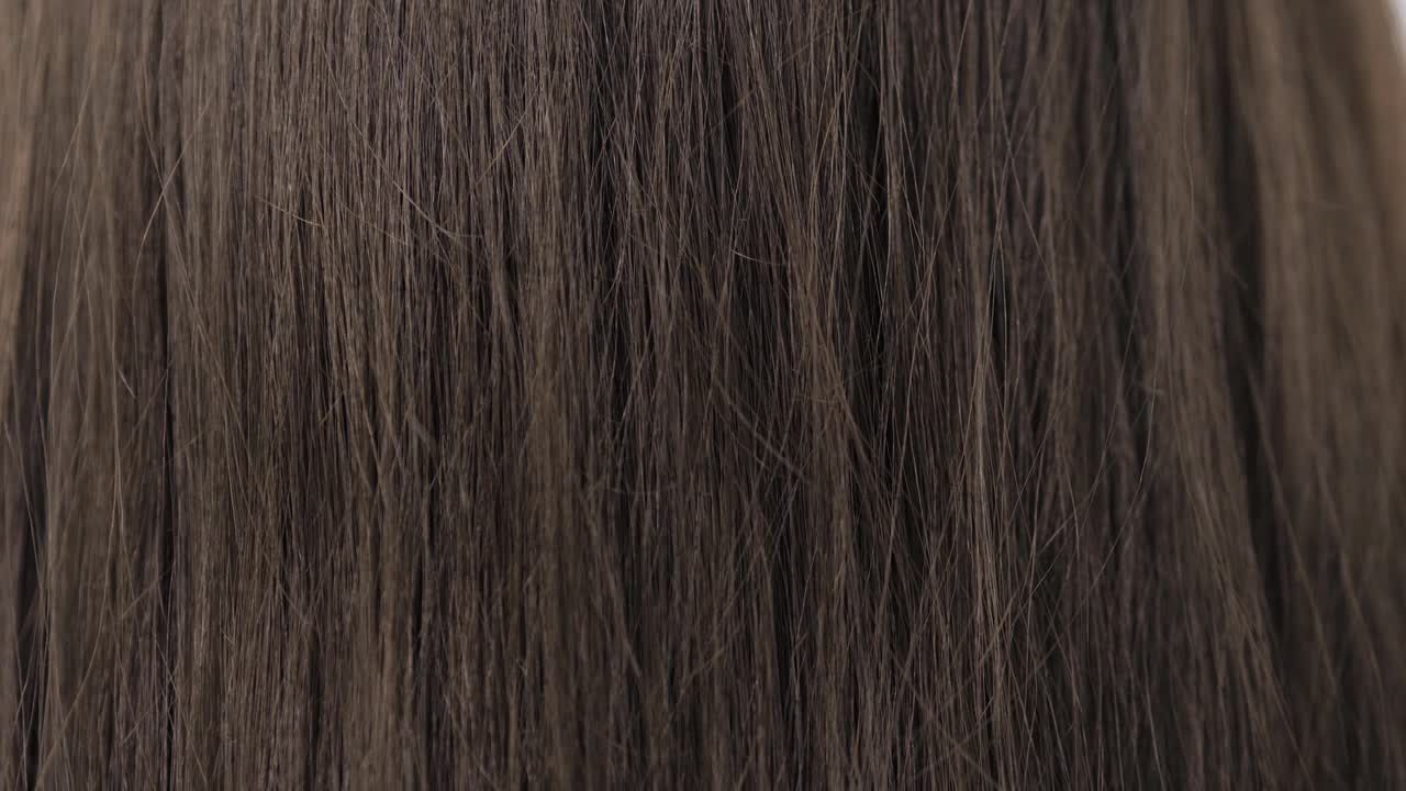 在拉直头发之前展示一下深褐色的头发视频素材