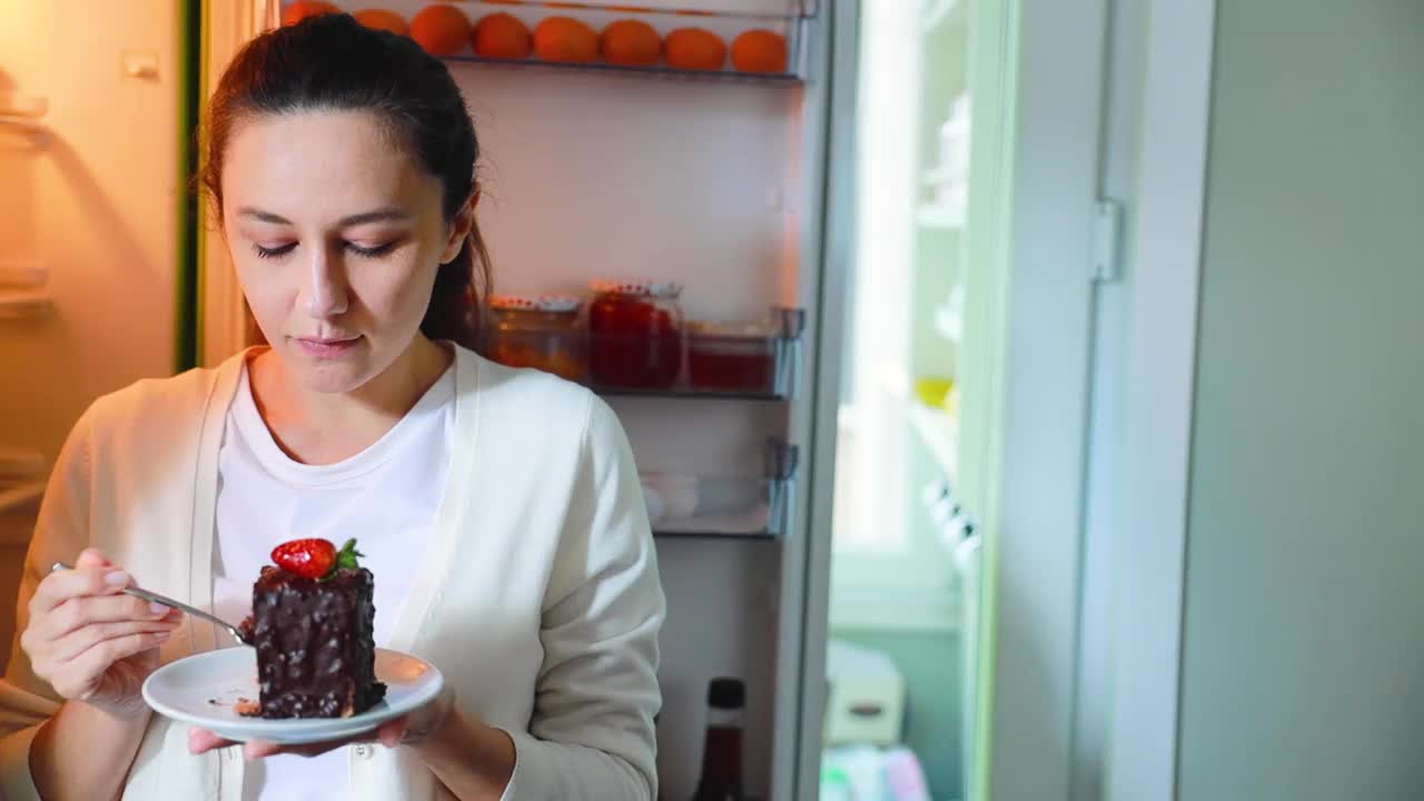 年轻女子用叉子吃可口的蛋糕感觉愉快视频下载