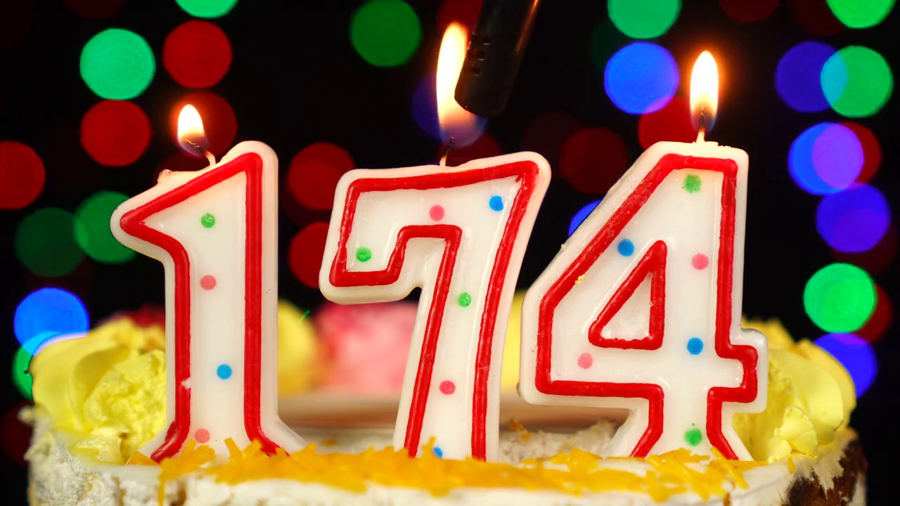 第174号生日蛋糕上面有燃烧的蜡烛。视频素材