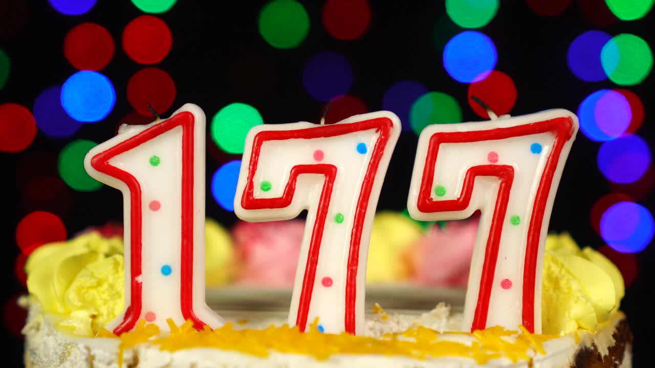 第177号生日蛋糕上面有燃烧的蜡烛。视频素材