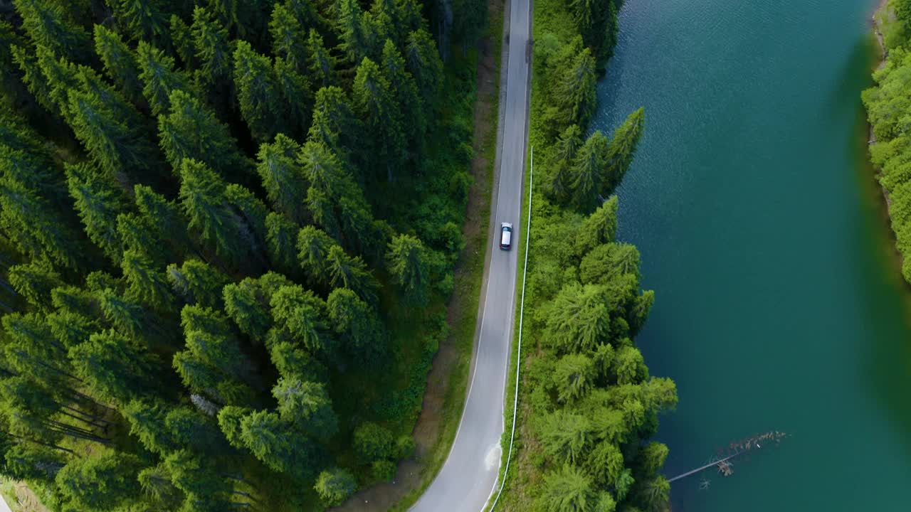 鸟瞰图的汽车驾驶通过森林和湖的一边。美丽的山路。在山路上开车。公路旅行。山地森林湖泊景观。汽车驶过松林视频下载