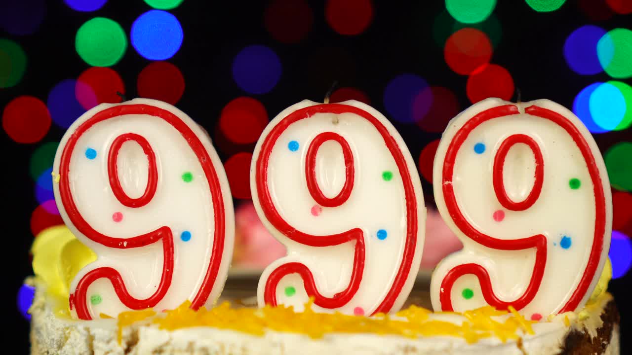 999号生日蛋糕上面有燃烧的蜡烛。视频素材