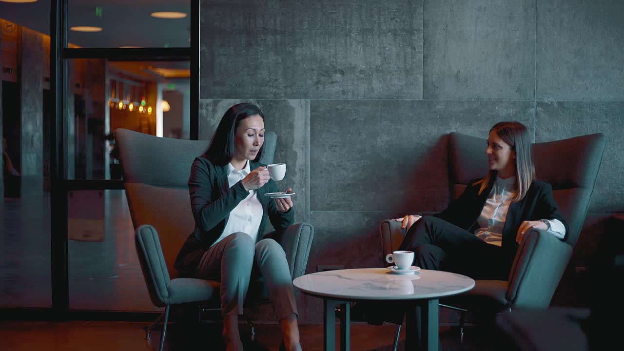 女商人在酒店的大厅里喝着咖啡聊天视频素材