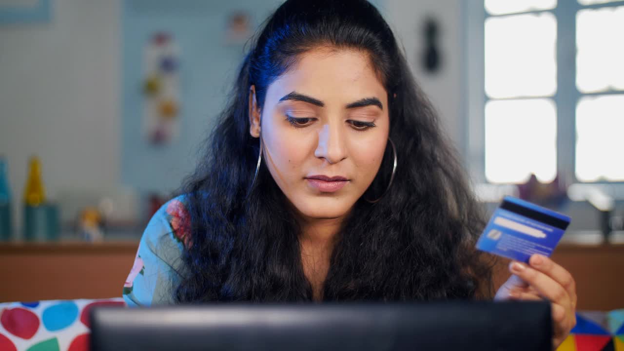 现代印度妇女在网上购物时把她的银行卡详细信息视频素材