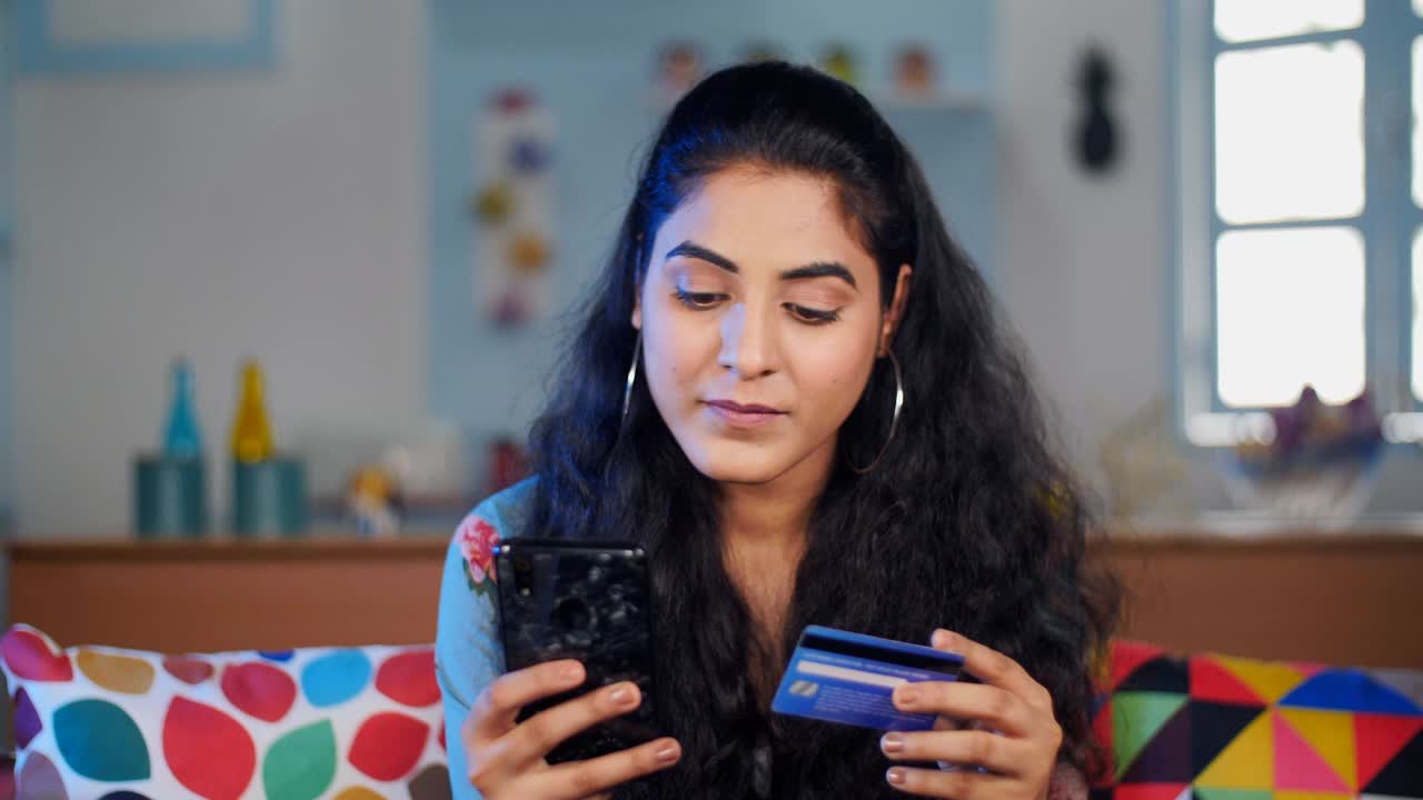 自信的印度女人把她的借记卡/信用卡信息存入手机视频素材