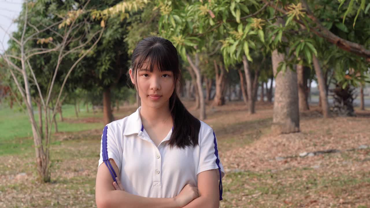 亚洲年轻女子的面部表情，拟人化的笑脸，双臂交叉视频素材