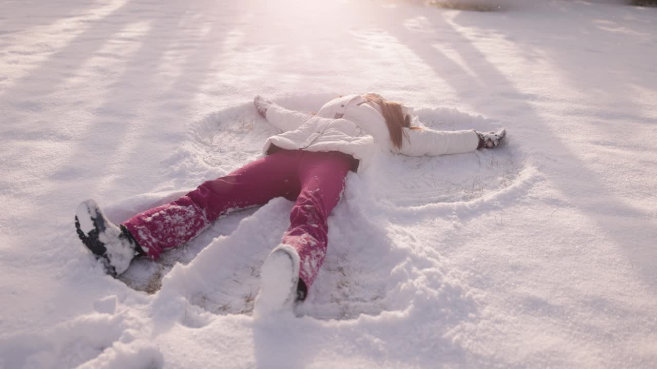 少女享受在新雪中做一个雪天使视频下载