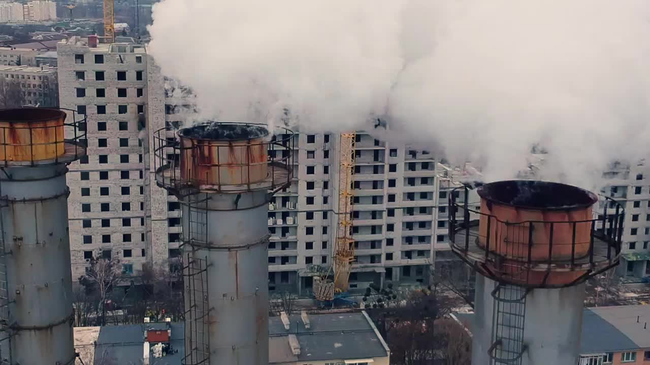 以城市为背景的冒着烟的烟囱视频素材