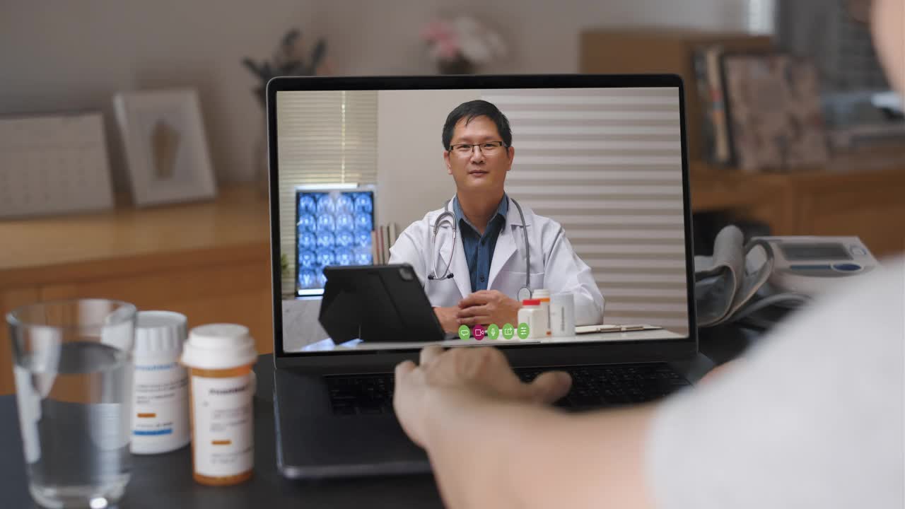 女病人在家用笔记本电脑与她的医生视频通话，病人有一个远程咨询师对她的疾病进行体检。视频素材