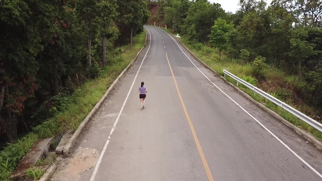 航拍:一个女人在马路上奔跑视频素材