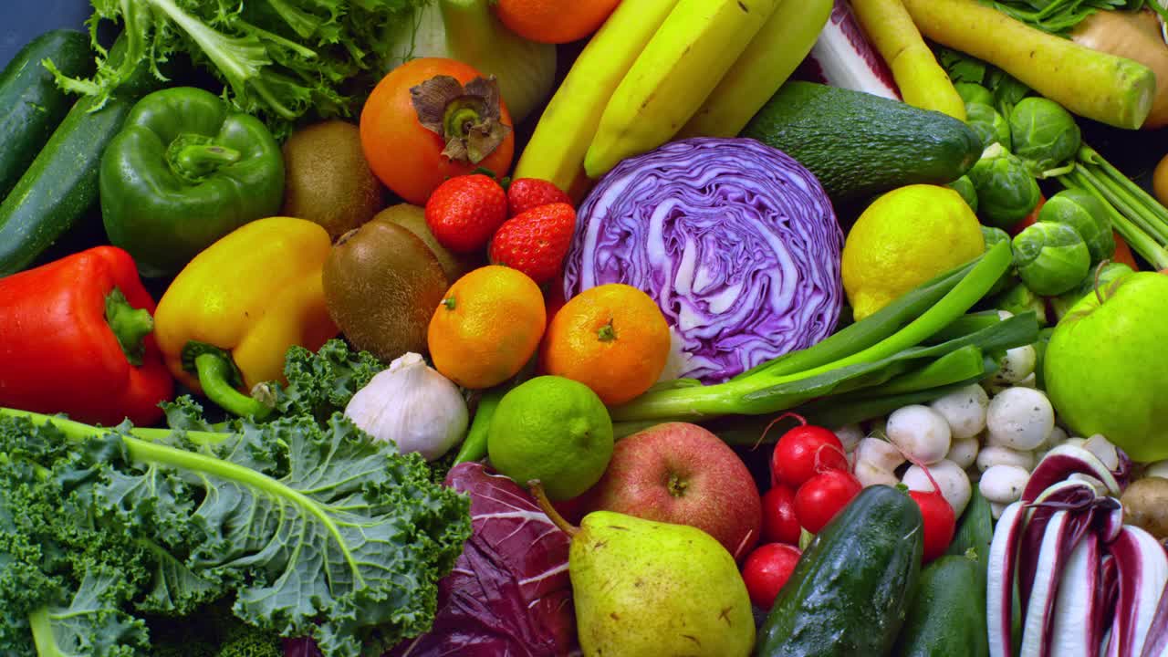 在盘子上旋转的水果和蔬菜的混合物视频下载