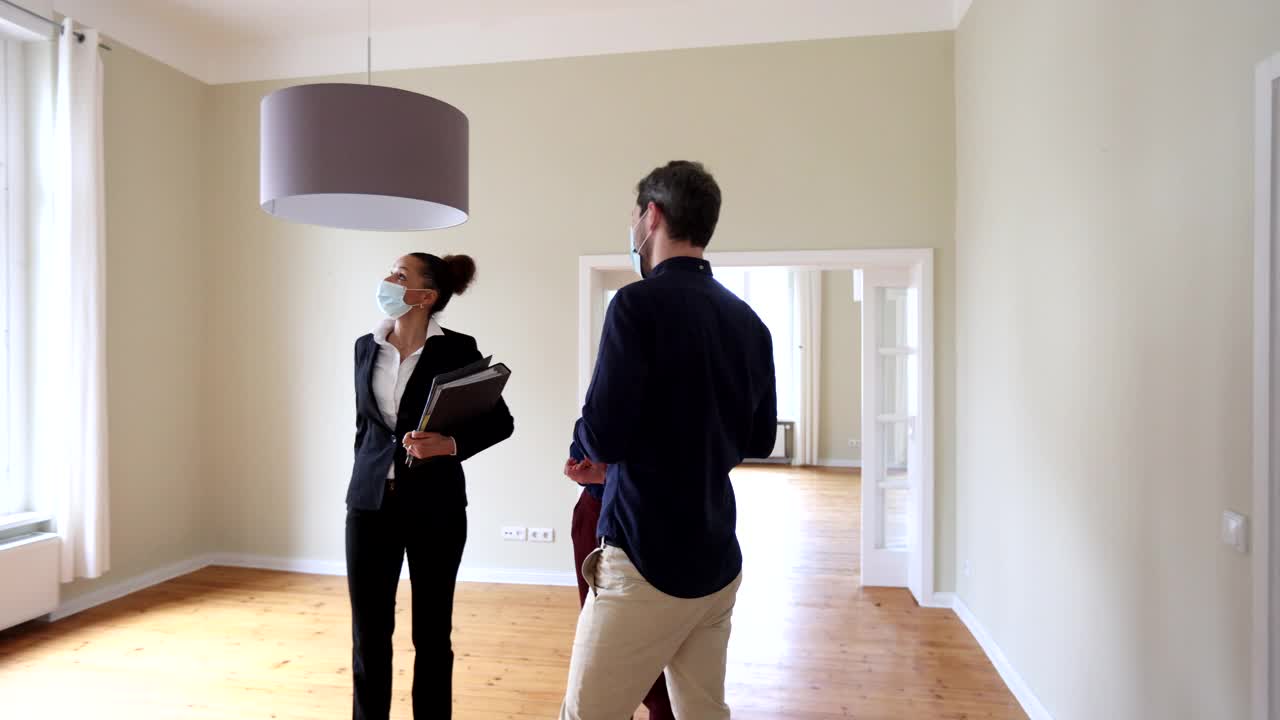 房地产经纪人向一对夫妇展示待售的新房子视频素材